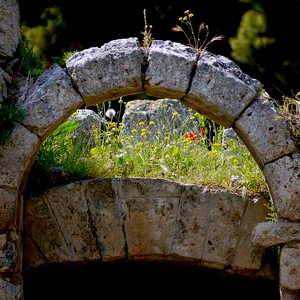 Arc en pierres au dessus d'une porte et fleurs à l'arrière plan - Grèce  - collection de photos clin d'oeil, catégorie rues